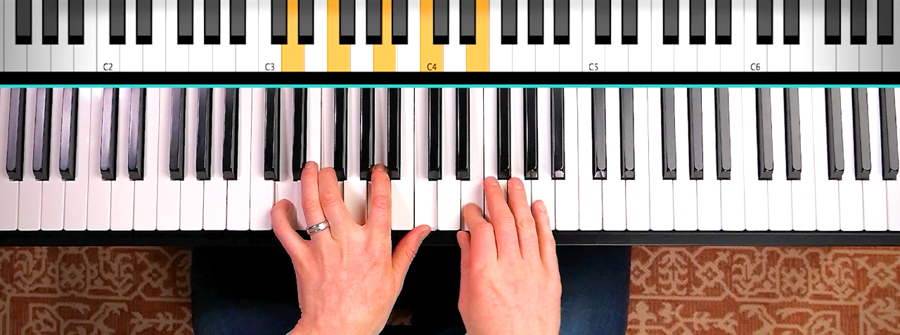 Hands playing piano notes looking from above