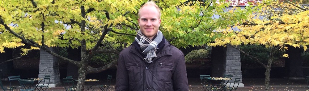 Julian Bradley photographed outdoors with green trees